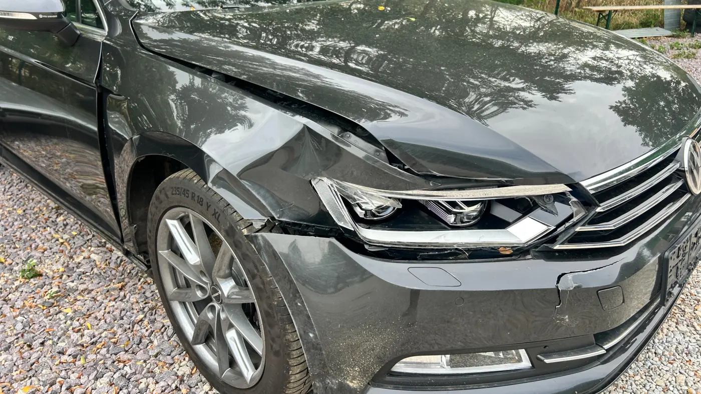 Poškodený predok Volkswagenu Passat po zrážke so zverou — nárazník, svetlomet, blatník a kapota