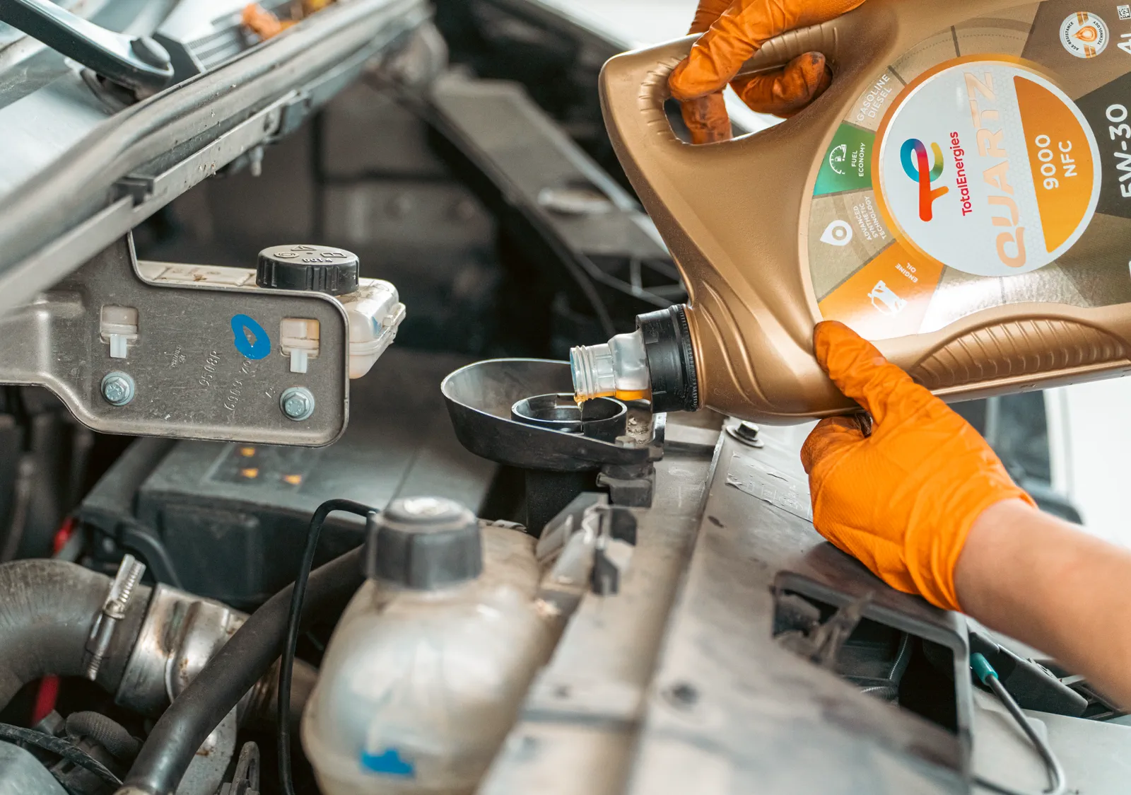 Autoservis — dolievanie motorového oleja pri servisnej prehliadke